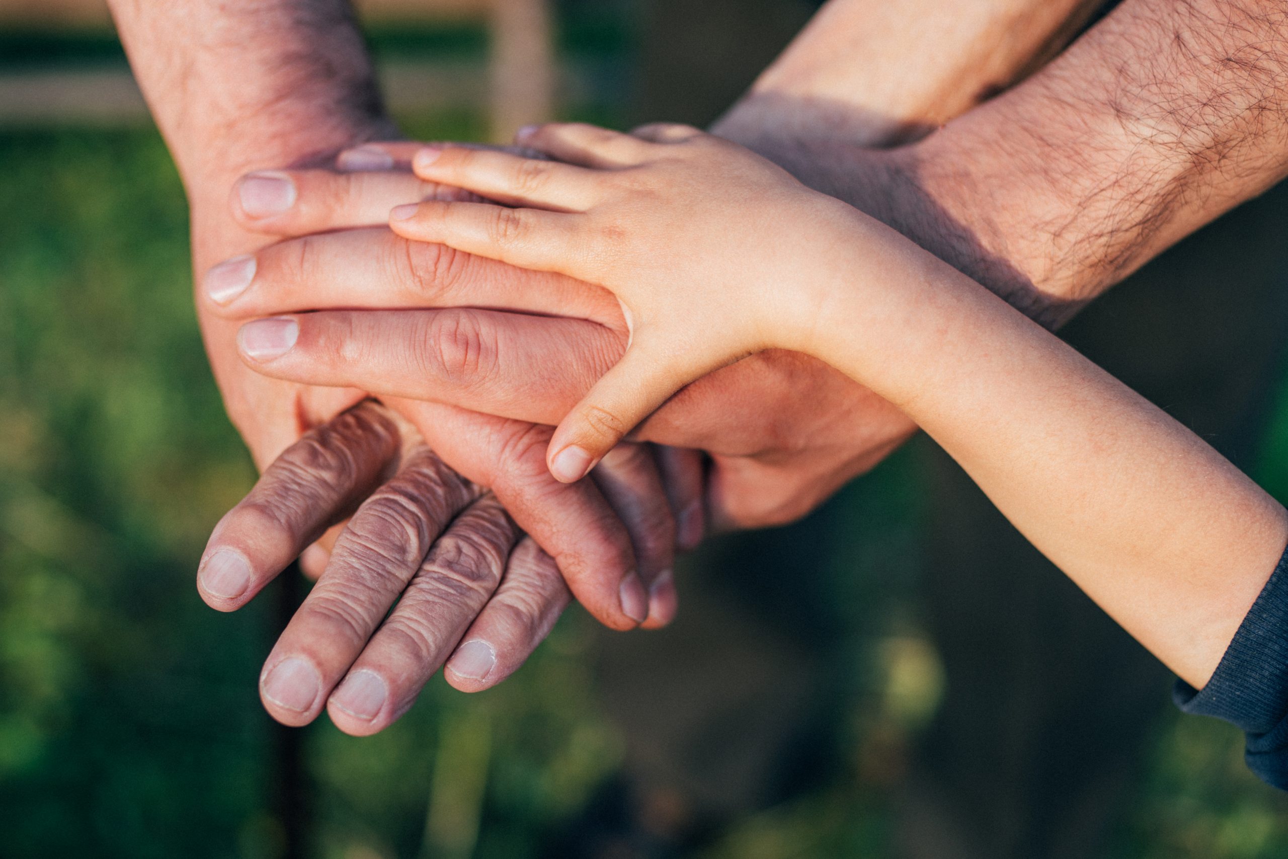 Close-up of group of people with stacking hands.